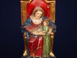 an image of a statue of a woman holding a child on a throne