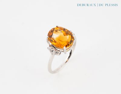 une image représentant une bague ornée d'une grosse citrine entourée de diamants