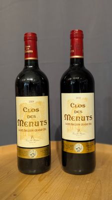 two bottles of wine sitting on top of a wooden table
