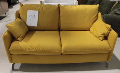 un canapé jaune avec des coussins dessus, dans un magasin