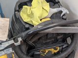 un gant jaune posé sur un aspirateur noir et jaune