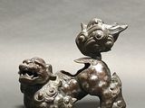 bronze figurine of a dog and a fish on a gray background