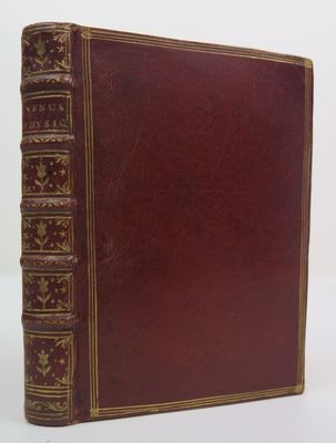 un vieux livre à la couverture rouge posé sur une surface blanche
