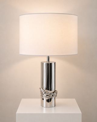 une table blanche sur laquelle est posée une lampe, près d'un mur