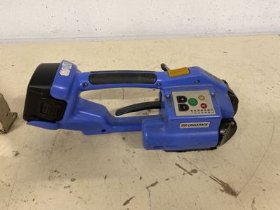 a blue electric tool sitting on the floor next to a piece of wood