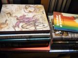 une pile de livres posée sur une table à côté d'une chaise