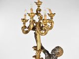 an antique bronze figurine of a boy holding a candelabra