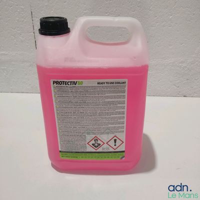une bouteille rose contenant un liquide, posée sur une table