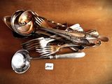 a pile of silverware on a brown surface