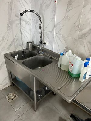 un évier avec un robinet et deux bouteilles d'eau posées sur le plan de travail