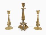 three antique brass candlesticks on a white background