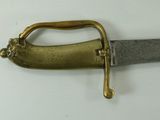 a gold handle on a sword on a white surface