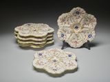trois assiettes ornées de fleurs sont posées sur une table