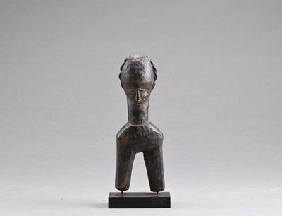 une statue représentant une femme, dont la tête repose sur un socle en bois