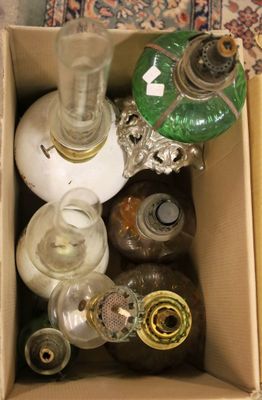 une boîte remplie de bouteilles et une lampe posée par terre
