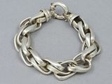 a close up of a silver chain bracelet on a table