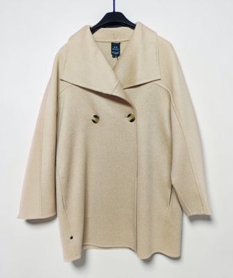 une blouse blanche suspendue à un cintre accroché au mur