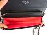 someone is holding a chanel wallet with a chain hanging from it