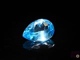 gros plan d'un diamant bleu sur une surface noire