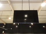 a large screen mounted to the ceiling of a building