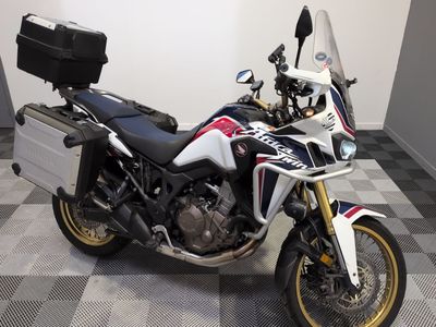 une moto qui est garée dans une pièce dont le sol est en damier
