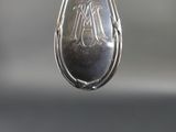 a silver spoon hanging from a hook with a message on it