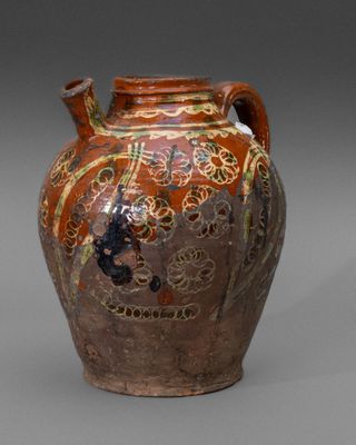un vase marron orné de motifs sur un fond gris