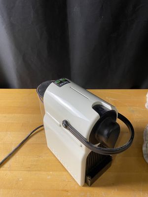 une cafetière posée sur une table en bois, à côté d'une tasse de café