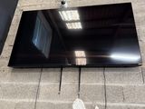 un téléviseur à écran plat posé par terre devant un mur