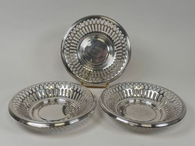 trois assiettes en métal argenté sur fond blanc