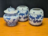three blue and white vases sitting on a wooden table