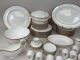 a lot of white and gold dinnerware on the table