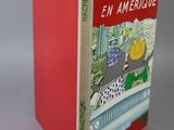 the book is red and has a picture of a cat in a car