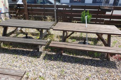 deux tables de pique-nique et un parasol sur le gravier