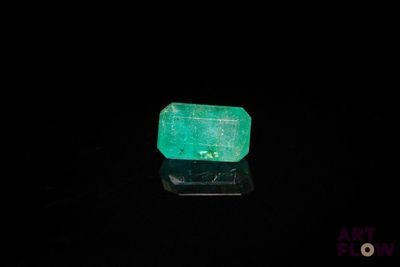 un gros plan d'une émeraude verte sur une surface noire