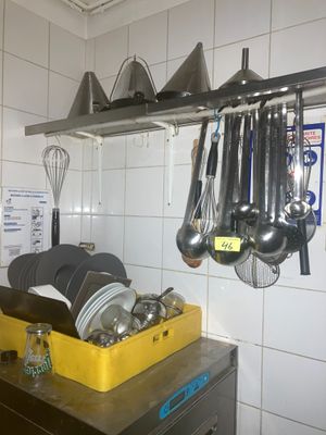 Des casseroles et des poêles sont suspendues à un support dans une cuisine.