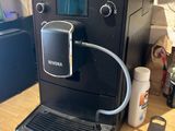 une machine à café noir posée sur une table en bois