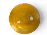 a yellow bowl with a tag on it on a white surface