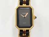 une montre noire et dorée, entourée d'une chaîne