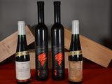three bottles of wine sit next to a wooden box on a table