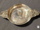 a silver bowl with a handle on a table