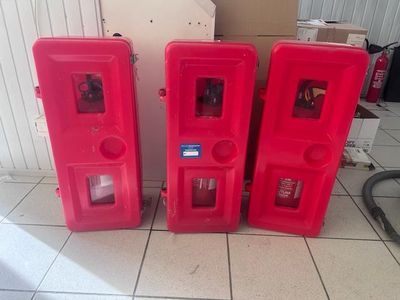 trois bouches d'incendie rouges posées sur un sol carrelé