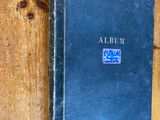 a black book on a wooden shelf with a blue cover