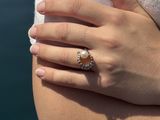 a woman holding a ring with a pearl on it