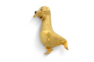 Broche en forme de canard plaquée or, aux yeux bleus, sur fond blanc