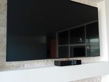 un grand téléviseur à écran plat fixé au mur au-dessus d'une cheminée