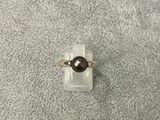 un gros plan d'une bague ornée d'une perle noire