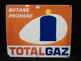 un panneau orange et bleu sur lequel figure une bouteille de Total Gaz