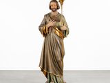 a statue of jesus holding a staff in a white room