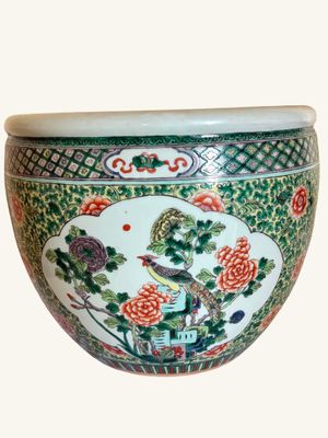 a green and white bowl with a bird and flowers on it